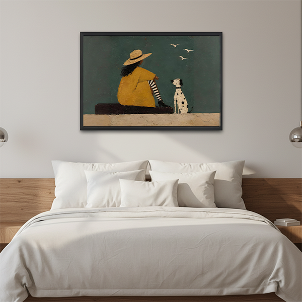 Framed contemporary woman and dog wall art displayed above a neutral sofa with cushions.