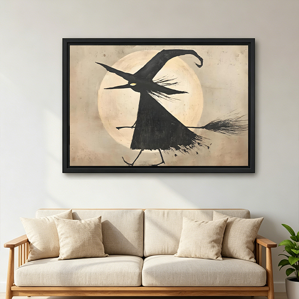 Framed flying witch moon canvas wall art displayed above a cream sofa in a bright living room