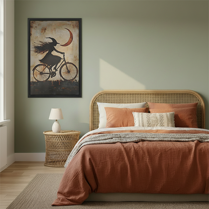 Framed gothic witch bicycle canvas wall art displayed above a cream sofa in a bright living room