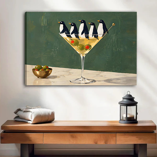 Framed penguin martini canvas wall art hanging above a wooden console with a black lantern.