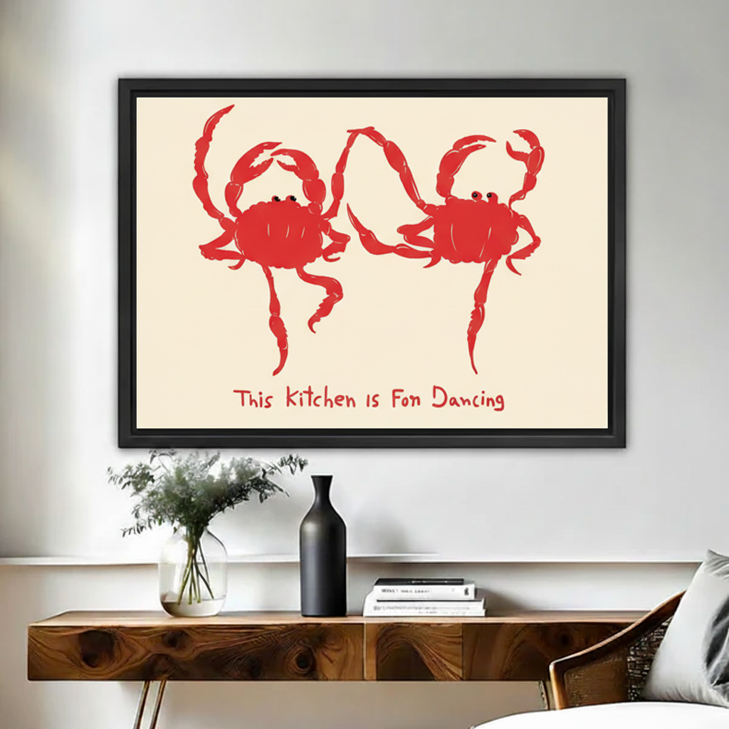 Framed playful red crab kitchen canvas wall art displayed above a wooden console with flowers and books