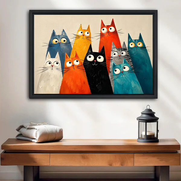 Framed quirky cats canvas wall art hung above a white bed with layered pillows in a calm bedroom.