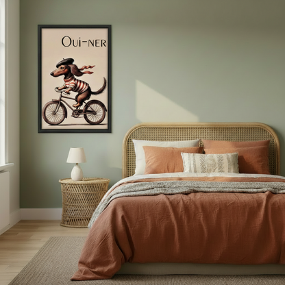 Whimsical French dachshund Oui-ner bicycle vintage poster wall art in black frame on sage green bedroom wall above rattan bed with terracotta bedding