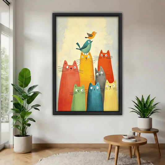 Black framed poster of a group of funny colorful cats in red orange green teal and yellow with two birds stacked on the tallest cat, hung on a white wall between two tropical potted plants
