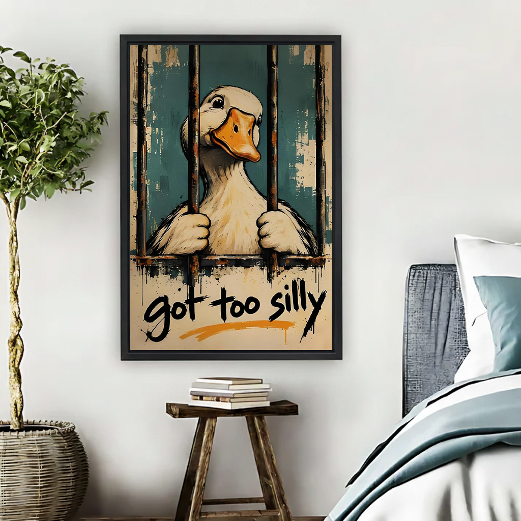 Funny duck canvas wall art with got too silly lettering in a black frame above an office desk.
