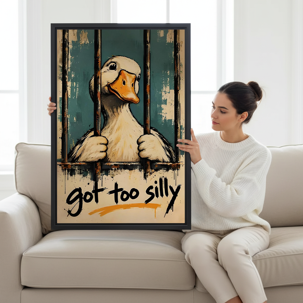Woman holding black-framed funny duck canvas wall art featuring a white duck and got too silly lettering.