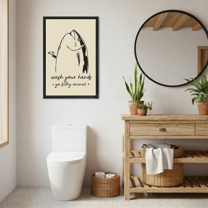 Funny fish wall art in a black frame above a toilet beside a wooden vanity and round mirror.