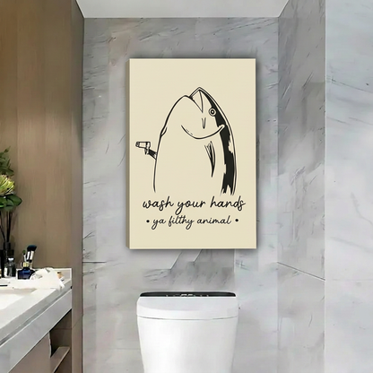 Unframed funny fish wall art with a wash your hands quote above a toilet against gray marble walls.