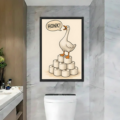 Funny goose canvas wall art in a black frame above a toilet, with HONK lettering and stacked rolls.