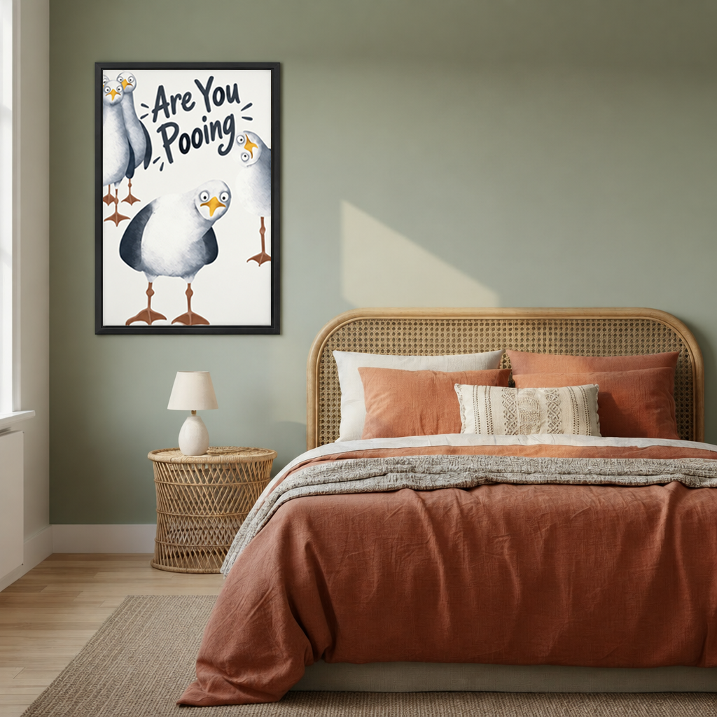 Funny seagull bathroom canvas wall art in a black frame beside a bed with a woven headboard.
