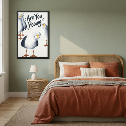 Funny seagull bathroom canvas wall art in a black frame beside a bed with a woven headboard.