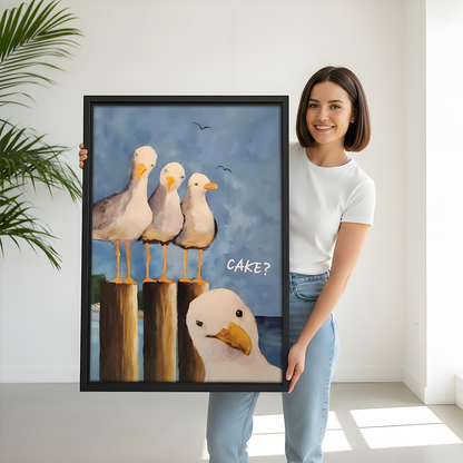 Woman holding large framed funny seagull CAKE coastal art print to show size in a bright room