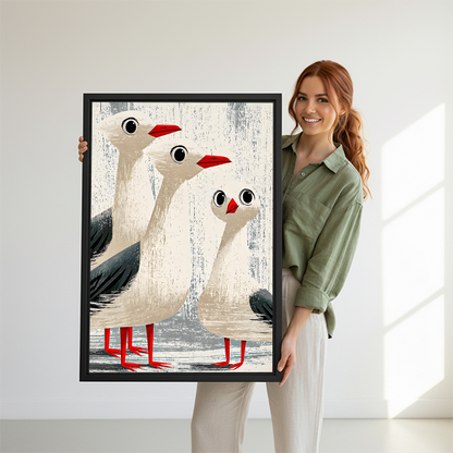 Smiling woman holding funny seagull trio vintage framed art print showing size reference on white studio background