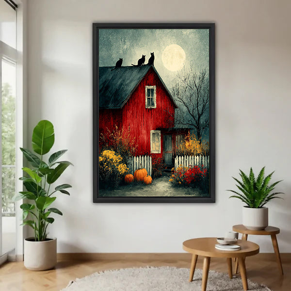 Halloween red barn three black cats full moon oil painting moody dark blue sky pumpkins autumn wildflowers black framed canvas wall art on white wall beside monstera plant and tiered round wood side table