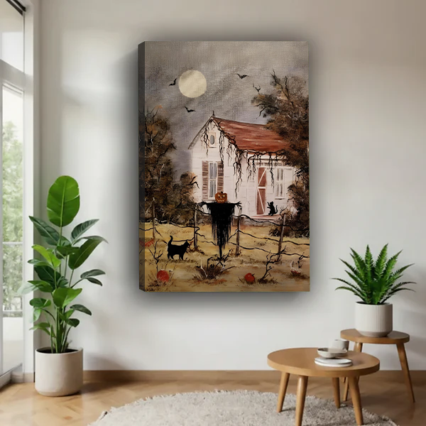 Woman holding framed Halloween cottage canvas wall art featuring a pumpkin-headed scarecrow, black cats, and flying bats.