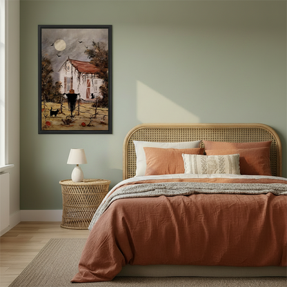 Rustic Halloween cottage canvas wall art in a black frame beside a rattan bed with terracotta bedding.