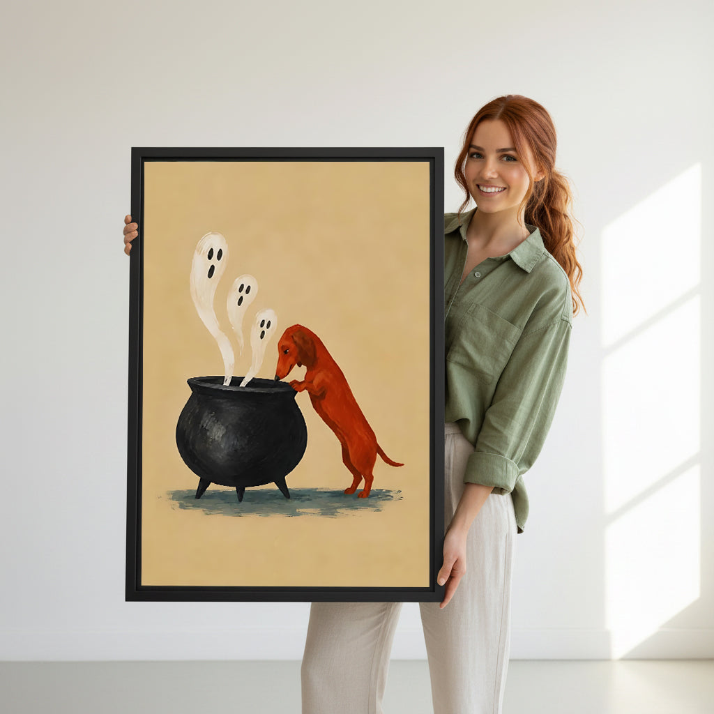 Smiling redhead woman holding large Halloween dachshund cauldron ghost cartoon rust red wiener dog three white ghosts black cauldron sandy background black framed canvas wall art size reference in bright white room with natural side light