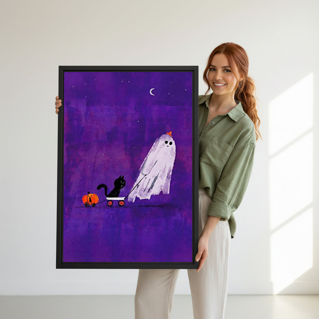 Smiling redhead woman holding large Halloween ghost black cat pumpkin cart purple night sky black framed canvas wall art size reference in bright white room with natural side window light