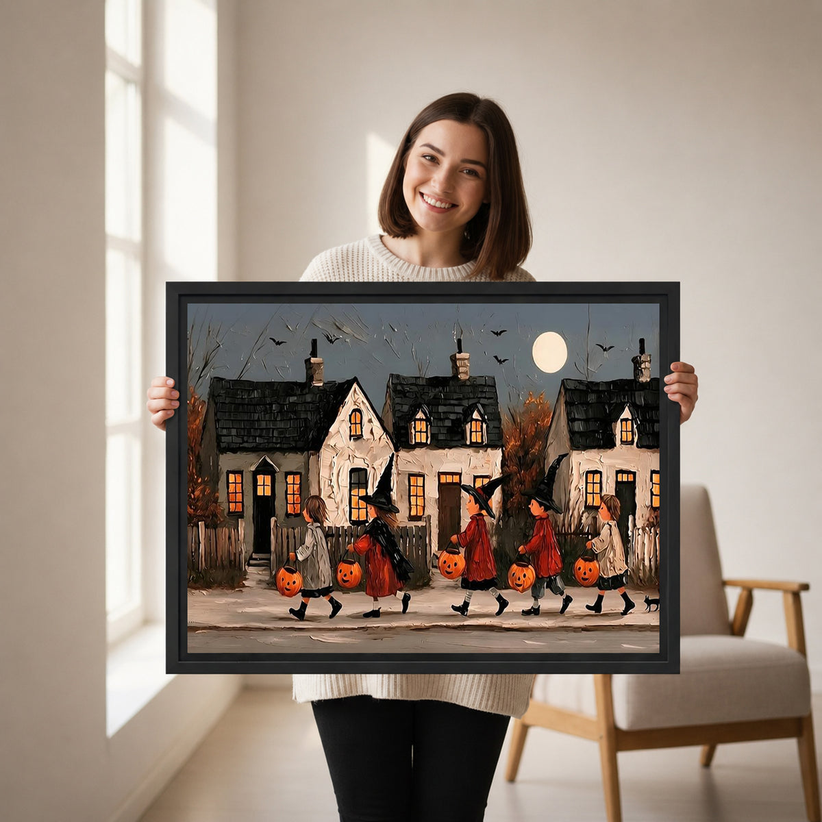 Woman holding framed Halloween parade canvas wall art featuring trick-or-treaters with pumpkin buckets beneath a full moon
