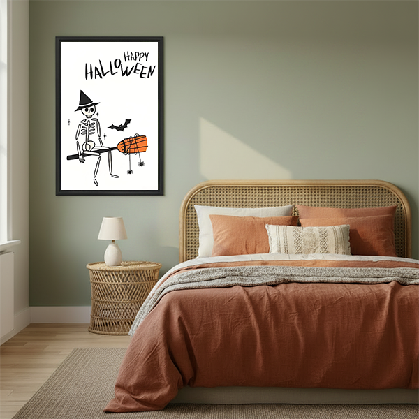Halloween skeleton canvas wall art in a black frame displayed beside a rattan bed with terracotta bedding.