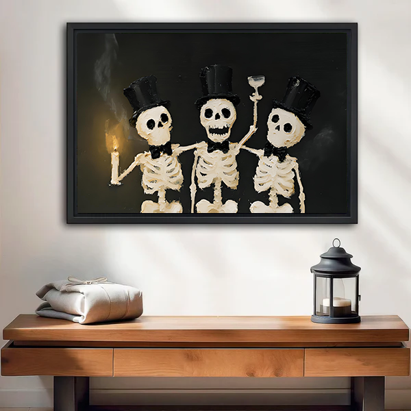 Black-framed Halloween skeleton trio canvas wall art with top hats displayed above a wooden console beside a lantern.