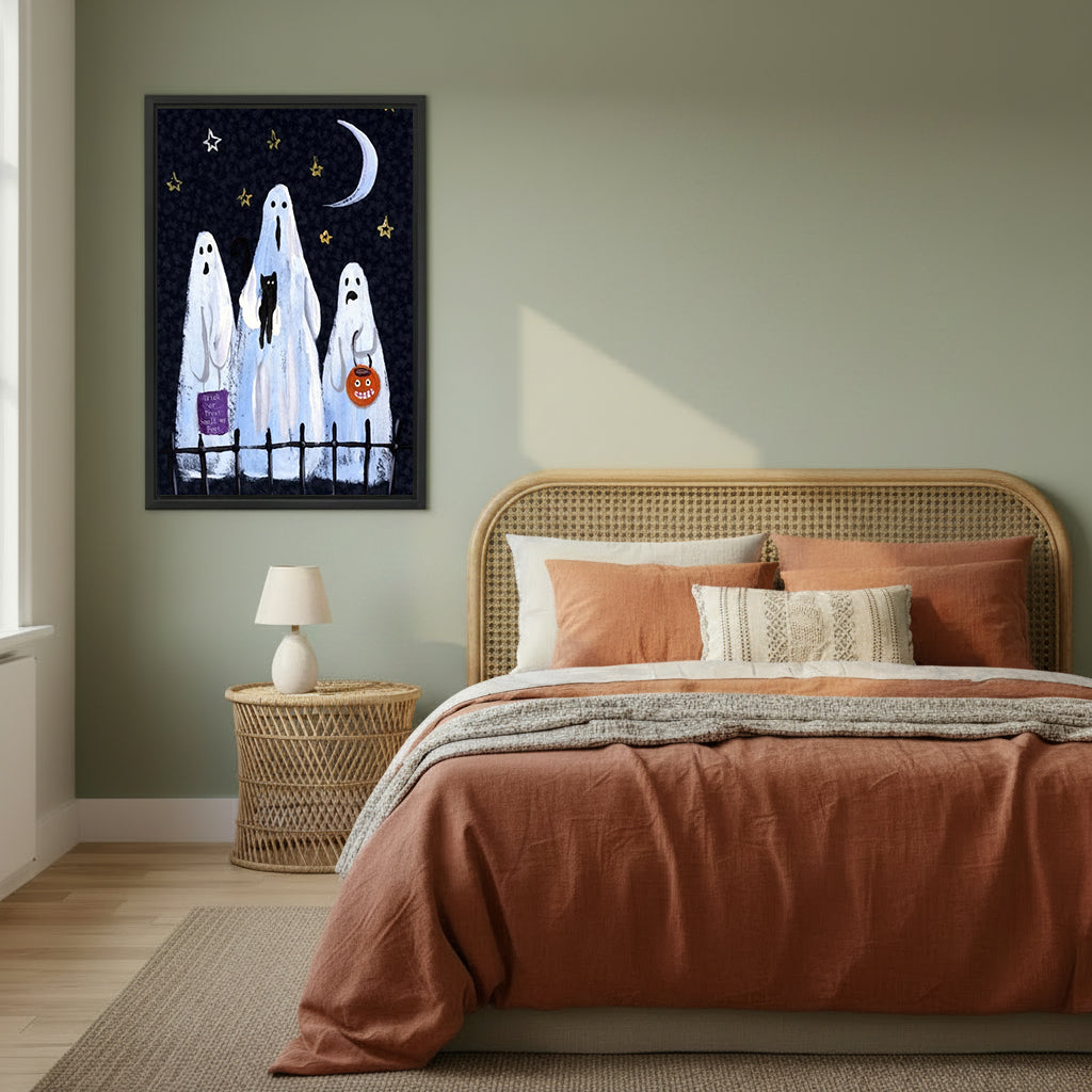 Halloween three white sheet ghosts trick or treat black cat pumpkin bucket night sky black framed canvas wall art on sage green wall above wide rattan arched headboard bed with terracotta linen and wicker nightstand