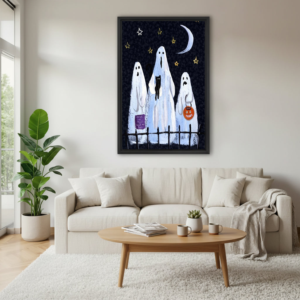 Halloween three white sheet ghosts black cat pumpkin bucket trick or treat iron fence black night sky black framed canvas wall art above cream linen sofa with oval wood coffee table and monstera plant