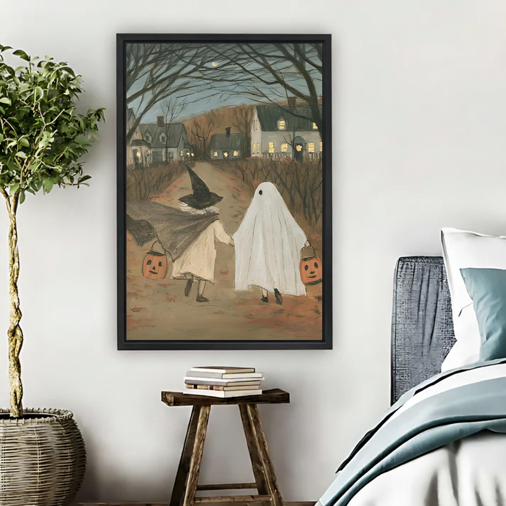 Woman holding framed Halloween trick-or-treat canvas wall art showing two children walking beneath bare trees