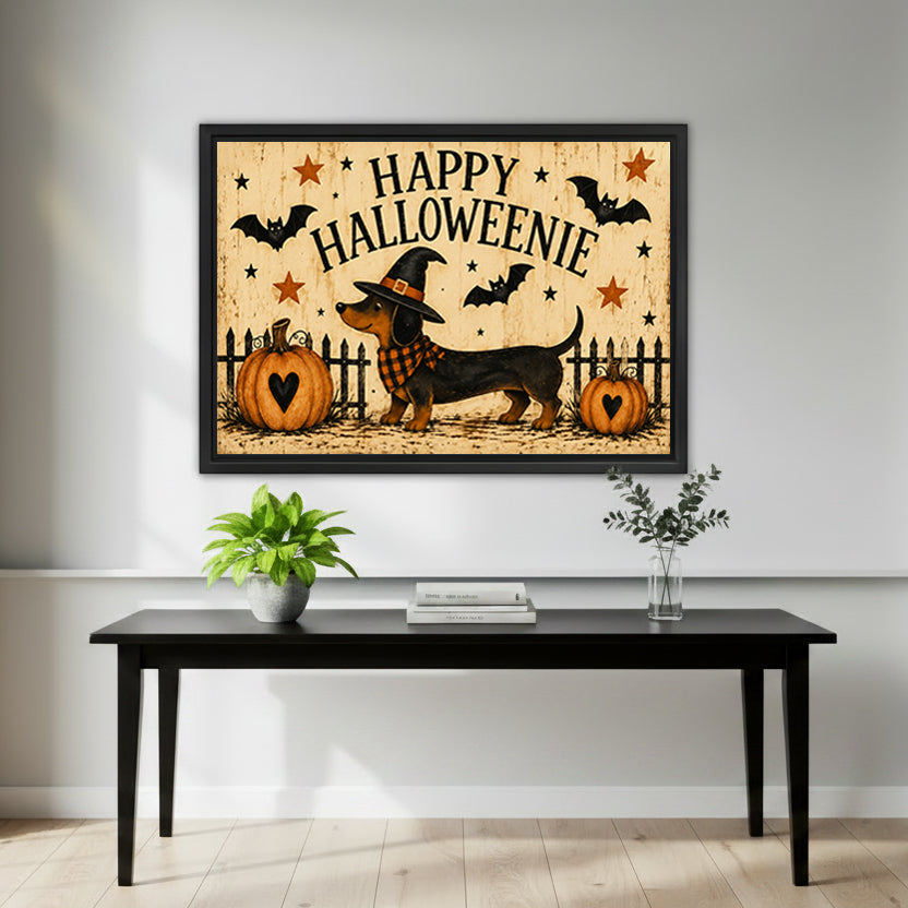 Happy Halloweenie dachshund witch hat plaid scarf heart pumpkins bats stars weathered cream background folk retro horizontal black framed canvas wall art on white wall above sleek black console table with green potted plant