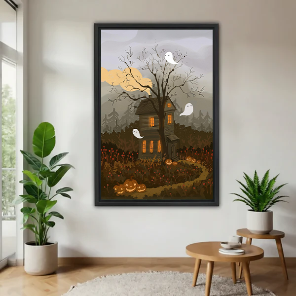 Woman holding black-framed haunted house canvas wall art with three white ghosts and glowing pumpkins.