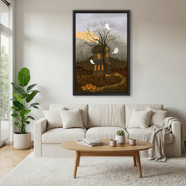 Framed haunted house canvas wall art with white ghosts on a sage bedroom wall beside a rattan bed.