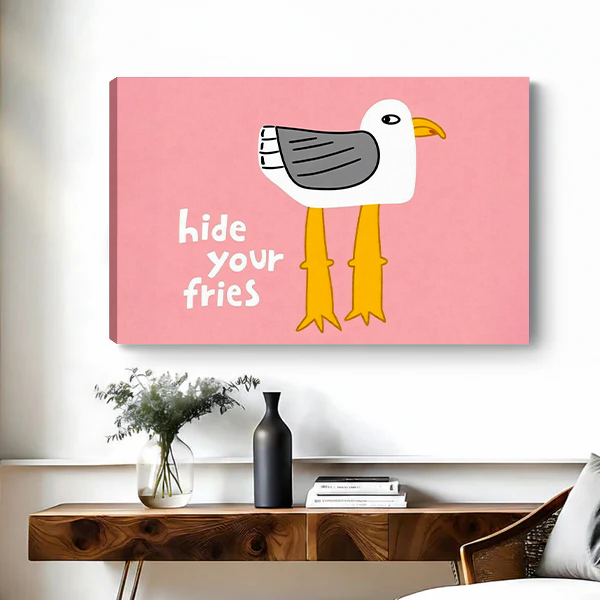 Framed Hide Your Fries seagull canvas wall art with pink background above a black bed.