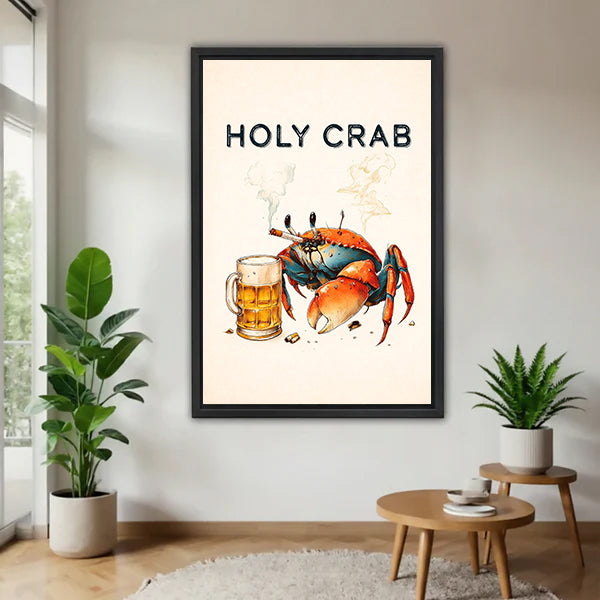 Black-framed Holy Crab beer canvas wall art on a white wall beside plants