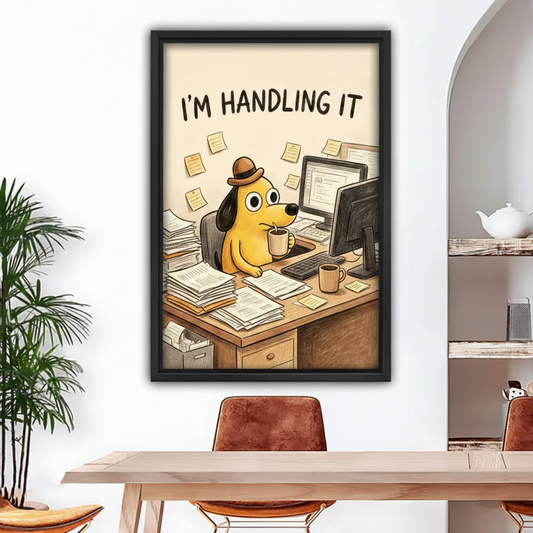 Black framed humorous wall print of a yellow cartoon dog surrounded by papers and sticky notes at a computer desk, hung in a modern dining space