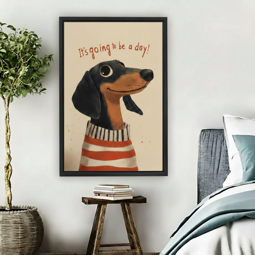 Black framed whimsical dachshund art print with It's Going to Be a Day quote hung in a cozy bedroom beside a rattan plant and wooden stool, featuring a cheerful cartoon dog in a red and white striped sweater on a warm beige background