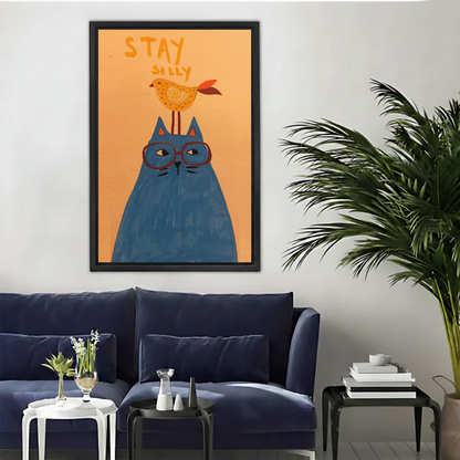 Whimsical cat and bird canvas wall art above a navy sofa beside a tall indoor palm.