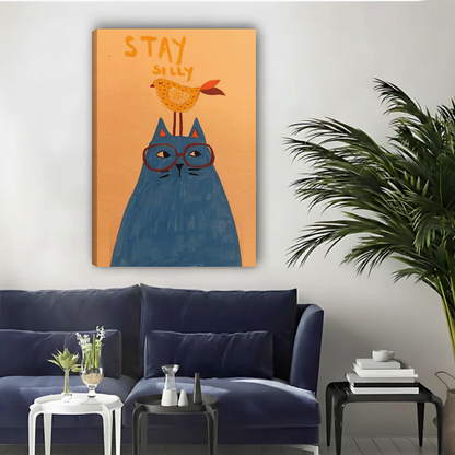 Unframed whimsical cat and bird canvas wall art above a navy sofa in a bright living room.