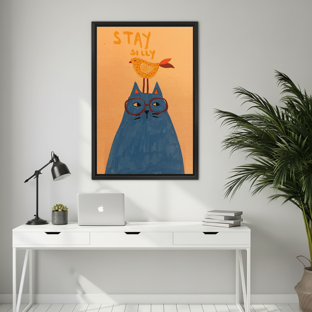 Whimsical cat and bird canvas wall art above a white desk with a laptop and black lamp.