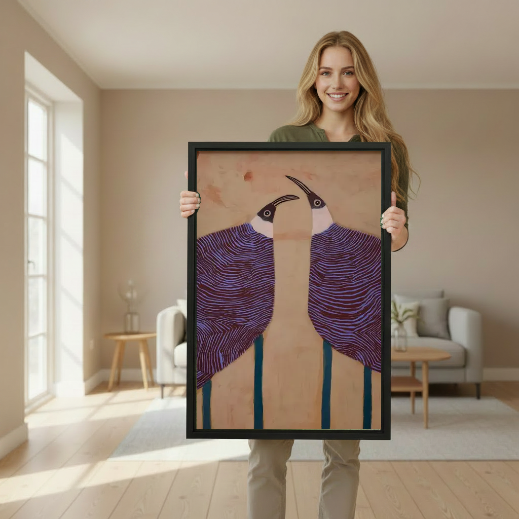 Graphic purple birds canvas wall art framed as a woman holds the artwork in a softly lit room.