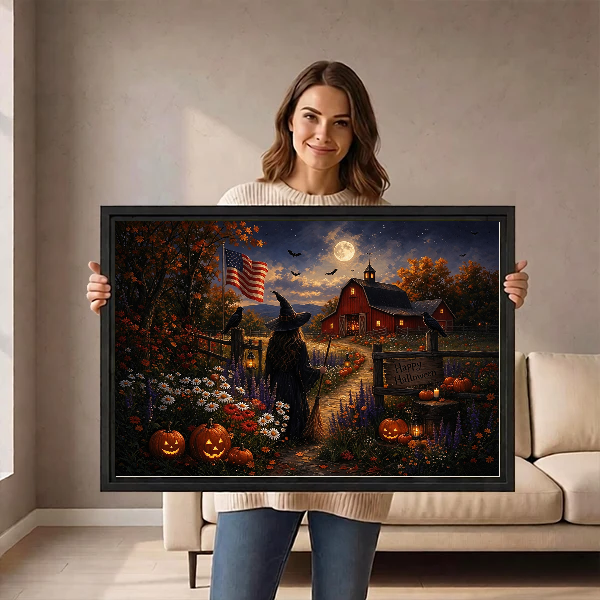 Moonlit Halloween Farm artwork held in a black frame by a woman beside a cream sofa.