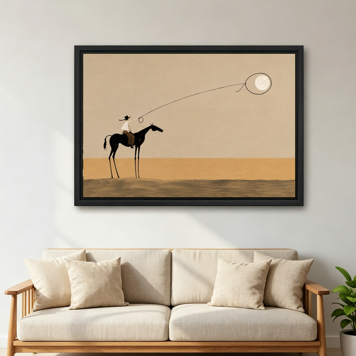 Surreal Cowboy Moon Lasso artwork in a black frame above a cream sofa with wooden arms.