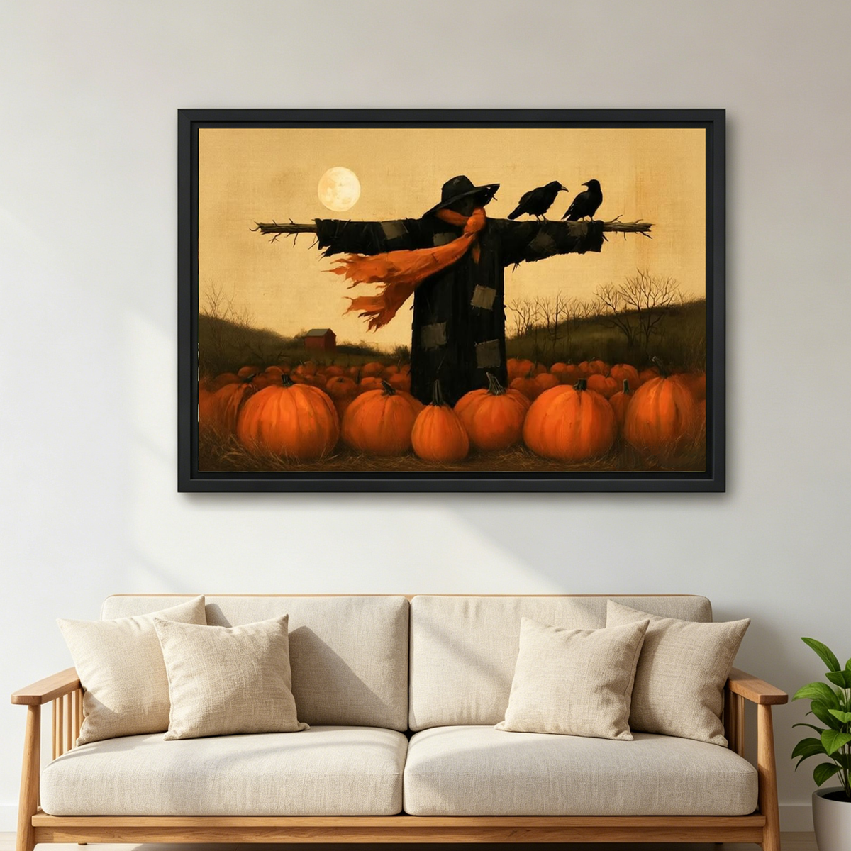 Autumn scarecrow canvas wall art in a black frame above a cream sofa with wooden arms.