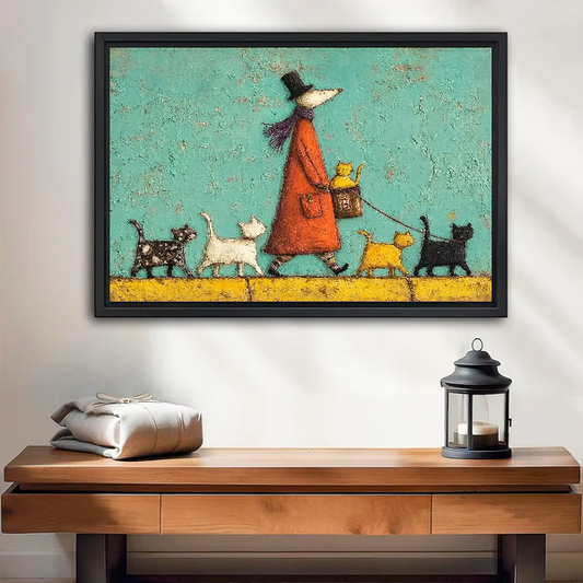 Whimsical cat walk canvas wall art displayed in a black frame above a wooden table and lantern.