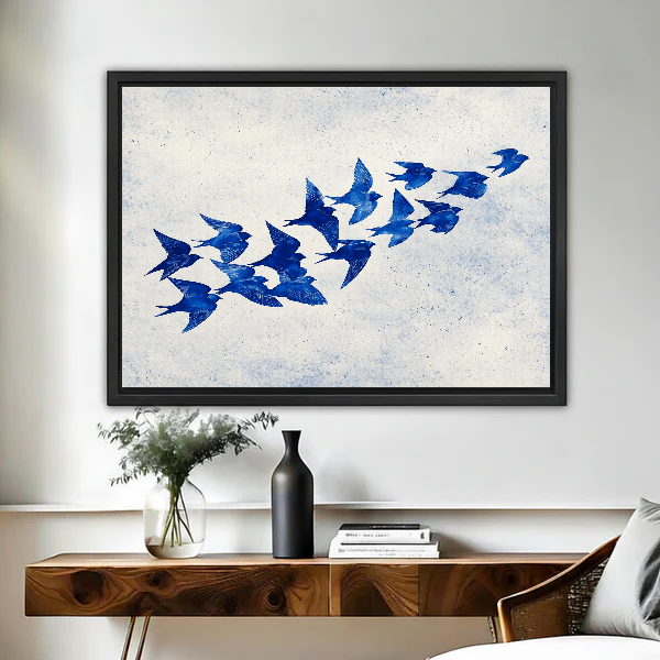 Cobalt Blue Swallows artwork in a black frame above a live-edge wooden desk.