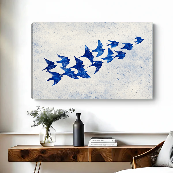 Cobalt Blue Swallows artwork as unframed canvas above a wooden desk with black vase.