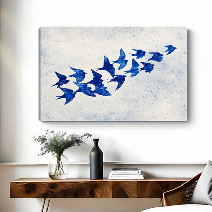 Cobalt Blue Swallows artwork as unframed canvas above a wooden desk with black vase.