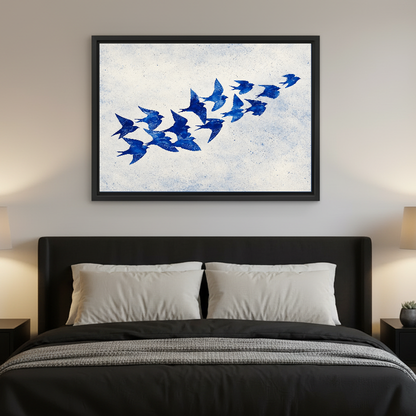 Cobalt Blue Swallows artwork in a black frame above a bed with dark headboard.