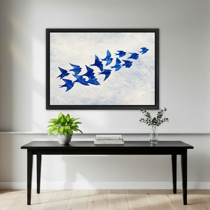 Cobalt Blue Swallows artwork in a black frame above a black console with plants.