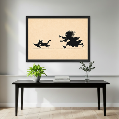 Funny Witch Cat Chase artwork in a black frame above a black console with plants.