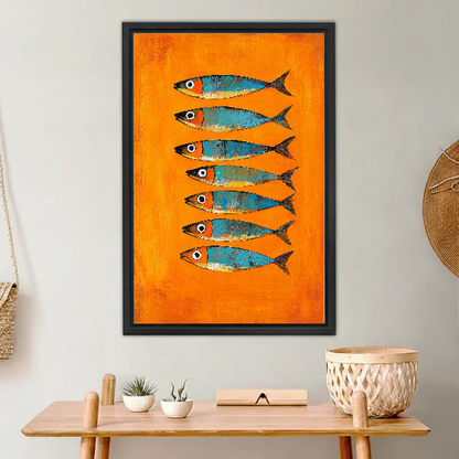 Orange Turquoise Sardines artwork in a black frame above a warm wooden console.